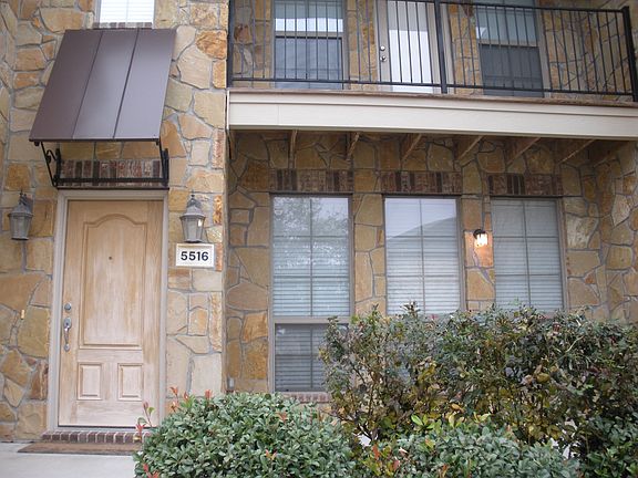 Closeup of home, red rose bushes in front of the home