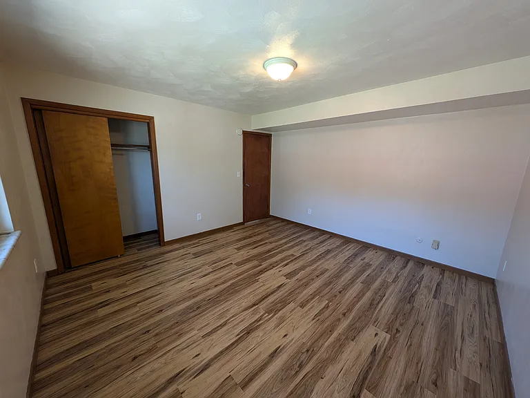 Spacious bedroom with luxury vinyl plank flooring for effortless cleaning.