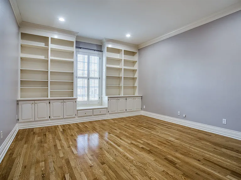 This bedroom is large and is split from the Primary Suite and the other two bedrooms. Offers built-in shelving, cabinets, and a walk-in closet. An ideal home office space.