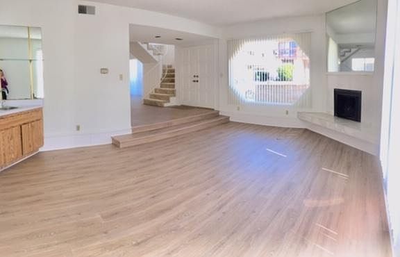 Currently, living room has red walls, dark cherry laminate floors a bar, yet will look closer to this when renovation is complete.