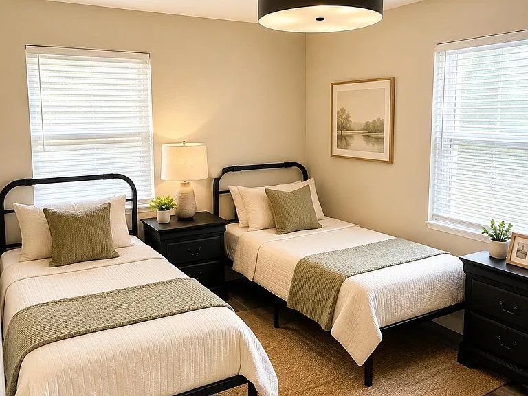bedroom with two twin beds, nightstands, and dual windows for natural light and easy shared living. (virtually staged bedding