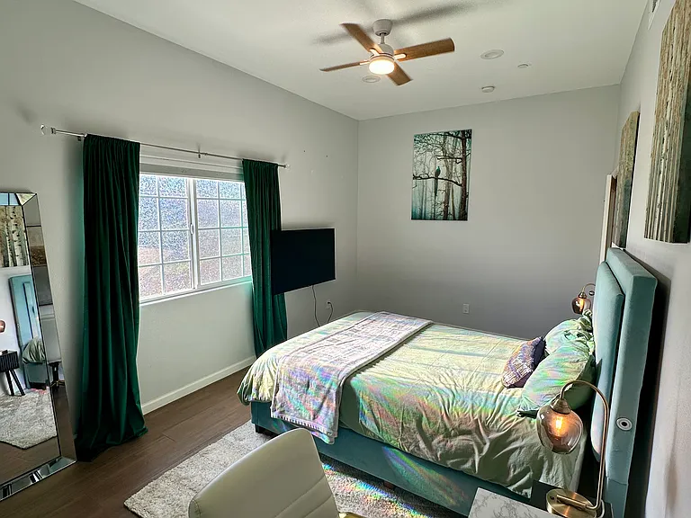 Downstairs bedroom 3 includes queen bed, TV, desk, and full length mirror