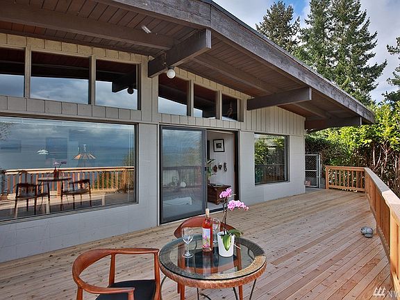 The front of your home is ALL WINDOWS to bring in the light while maximizing the stunning views! Sliding doors lead to open living/kitchen.  Window on far right is the master bedroom.  Note deck wraps around to back of home!