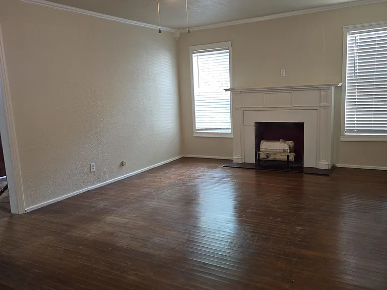 Large formal living room with fireplace and natural light