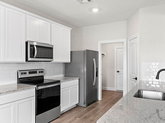 The kitchen of the Cypress has sprawling granite countertops.