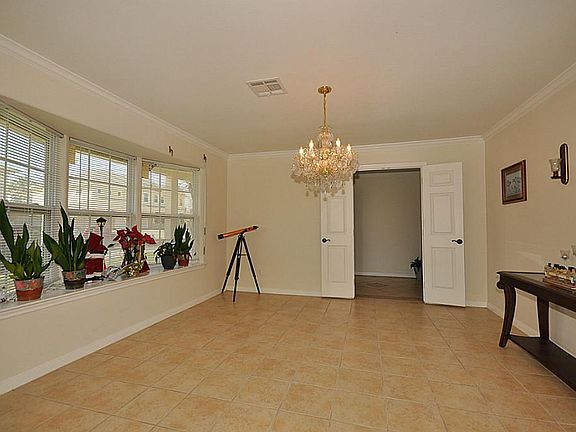 Window seat and chandelier invite you in. Tile floor and crown molding.