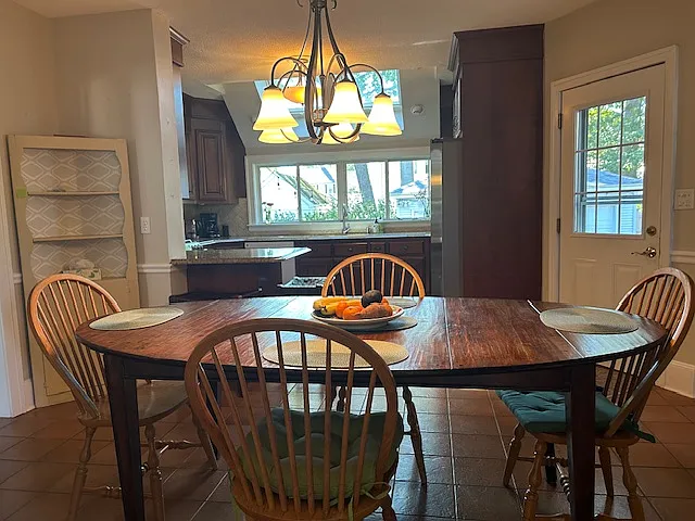 large kitchen dining and kitchen two bar stools. lovely view of back yard from kitchen with 2 skylights