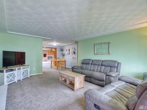Living room with coffered ceiling and a gas fireplace with brick surround.