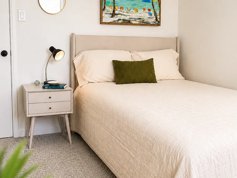 Cozy bedroom featuring a comfortable bed, dresser, nightstand, and ceiling fan.