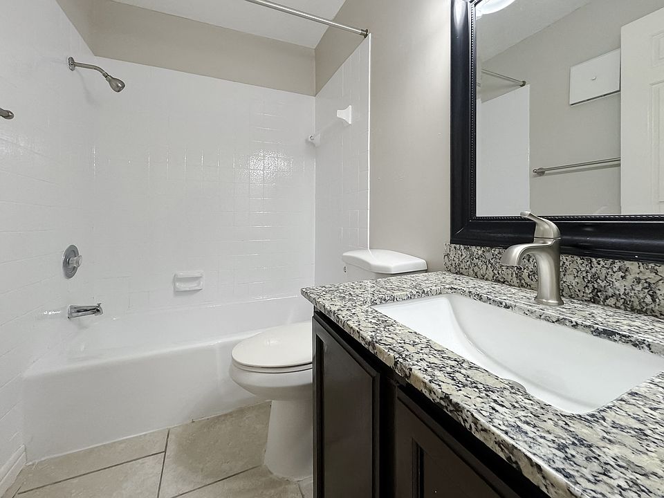 Stylish bathroom featuring granite vanity and tub-shower combo at Los Cedros Apartments in Brownsville, TX.