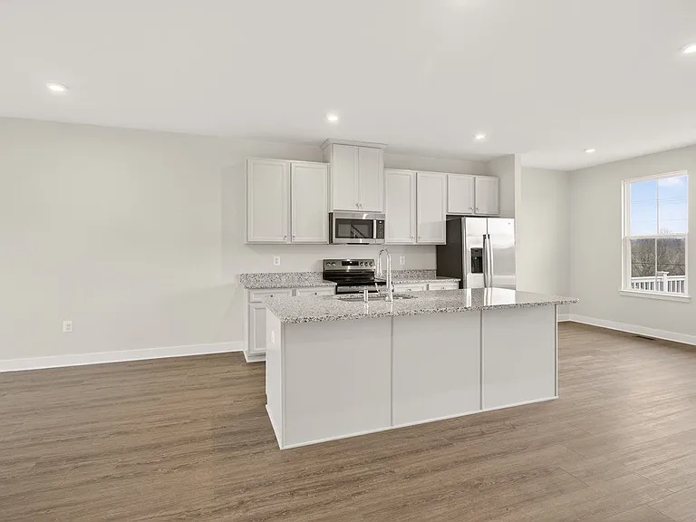 Modern kitchen with granite countertops, stainless steel appliances and a generous island