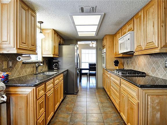 Tasteful Tile back splash and coordinating floor tile from Entry through Dining, Kitchen, Breakfast and into Utility.