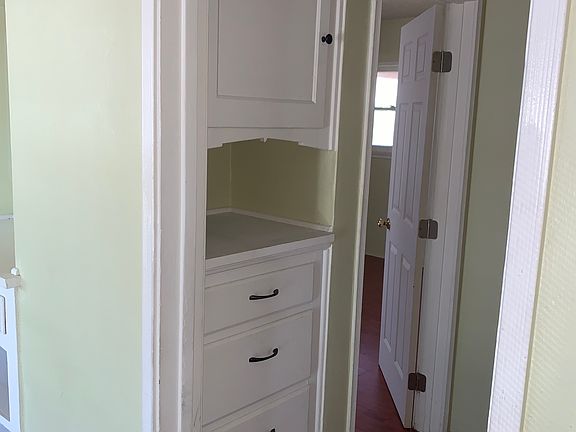 hallway with built in cabinets and drawers