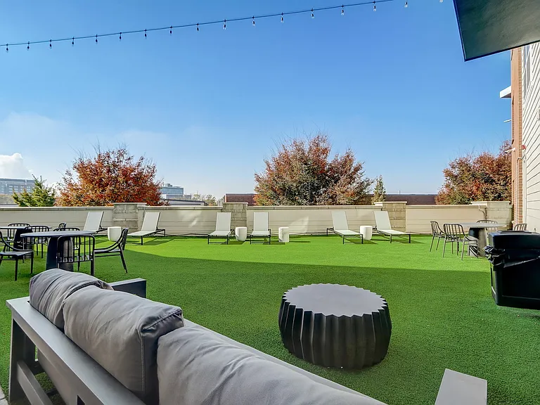The outdoor lounge at Ralston Apartments in Downtown Indianapolis, featuring comfortable seating, dining areas, and lounge chairs, perfect for socializing and relaxing.