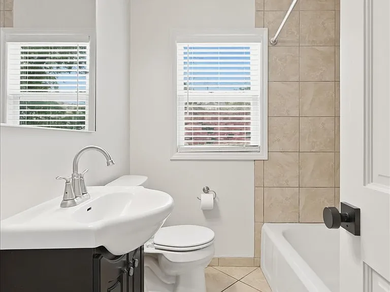 Main floor bathroom. New lighting, new exhaust fan, new toilet, new mirror. Tile floor and shower surround.