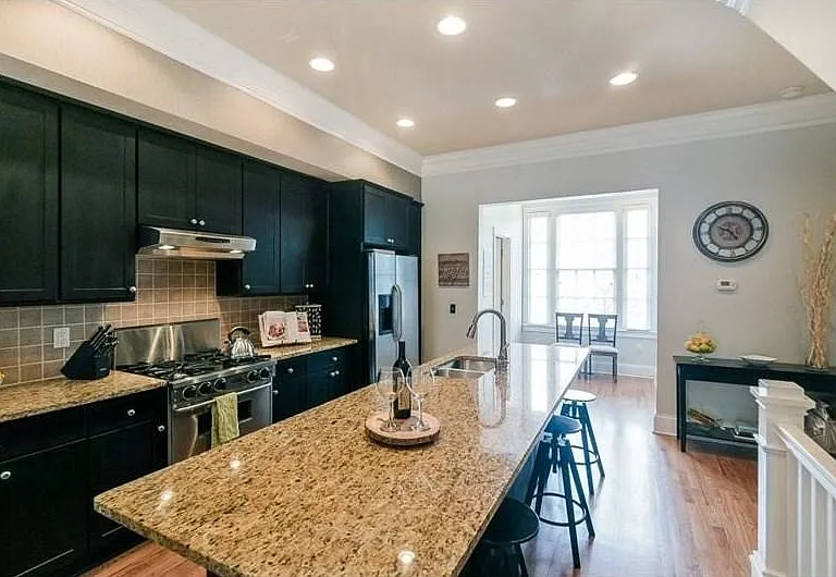 Granite countertops, stainless steel appliances, a tile backsplash, and recessed lighting