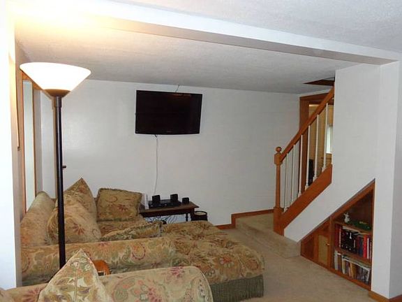 The other end of the living room with an open stairway.