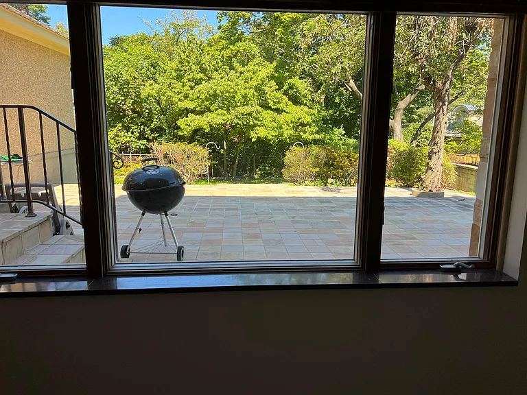 Pella stationary center window with operating casement windows in lower-level family room with marble window sills
