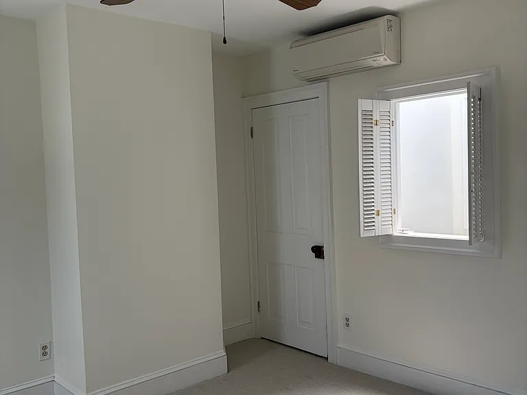 Primary bedroom includes mini-split air conditioning unit, as well as interior window to skylight.