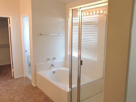Master bathroom with a tub, shower and walk-in closet