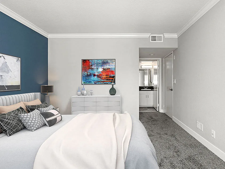 Carpeted bedroom with blue accent wall.