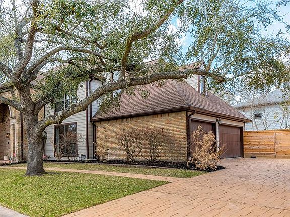 One of the two live oaks spanning the front lawn. This corner lot home on private cul-de-sac home offers extra parking spaces with large stamped concrete circle driveway with triple wide space in front of the garage doors.
