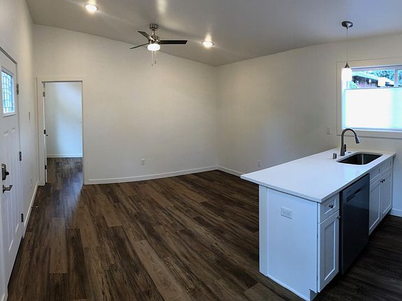 View of living room from kitchen. Front door on the left.