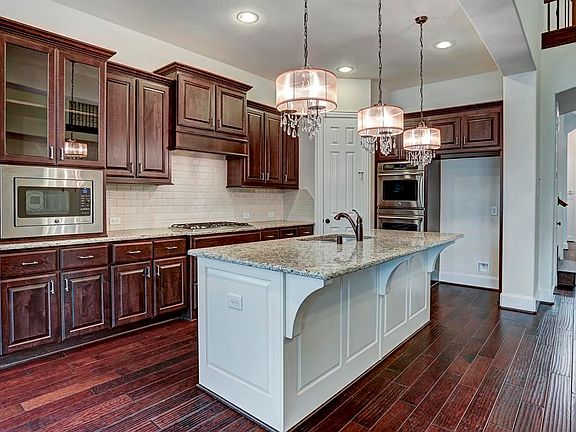Island kitchen boasts stainless appliances, abundant storage, and a breakfast bar.