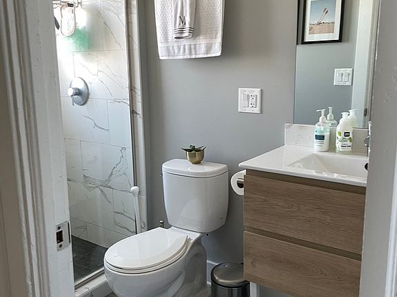 FULL BATH WITH WALK IN SHOWER FITTED WITH QUARTZ COUNTERTOP ON SINK AND QUARTZ TILED SHOWER