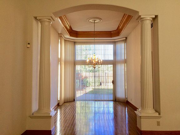 Formal Dining Room with crown moulding in high ceiling; Connection door to Kitchen is behind right column.