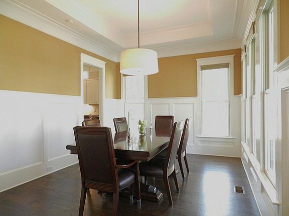 Formal dining room features a trey ceiling, period wainscoting wall trim and lots of windows filled 