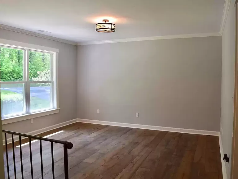Bright Living Room with wood flooring facing the front of the house.
