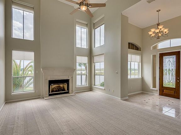 FOYER OPENS TO A GRAND 2 STORY DEN WITH FIREPLACE AND CAST STONE SURROUND. TALL WINDOWS OFFER PANORAMIC VIEWS OF CLEAR CREEK.