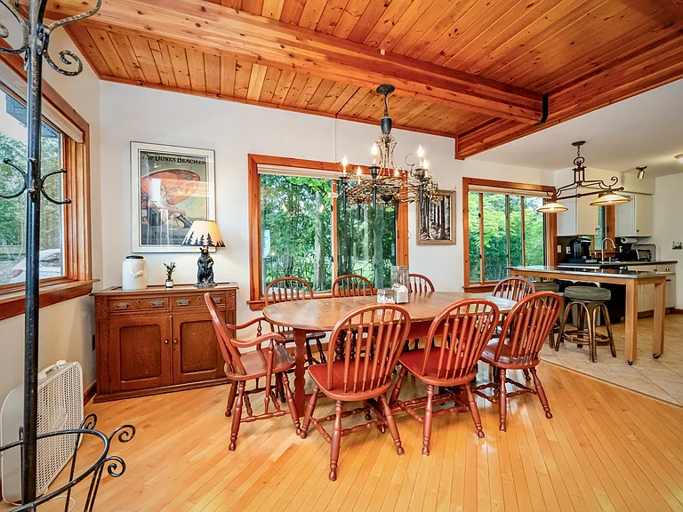 Spacious dining area with rich wood ceilings, abundant natural light, and easy flow into the kitchen_perfect for gathering and entertaining.