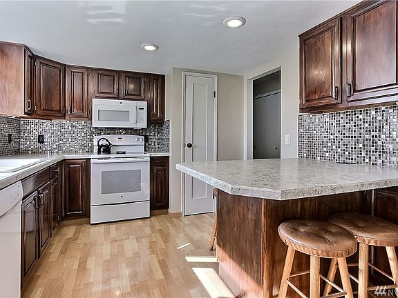 Kitchen view, great breakfast island, note backsplash and included appliances. 