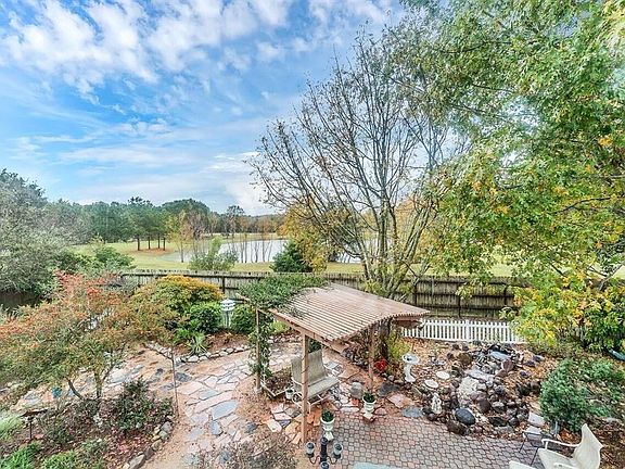 View from the upstairs across the manicured backyard, to the pond on the property of the rear neighbors.