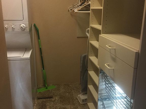 Lots of storage in custom Closets Plus walk-in closet with convenient washer and dryer.