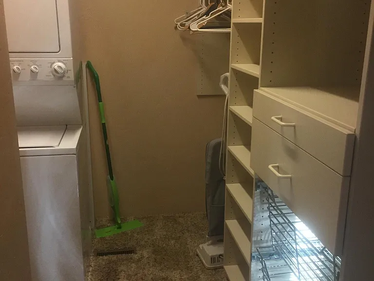 Lots of storage in custom Closets Plus walk-in closet with convenient washer and dryer.