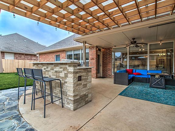Built in grill, white granite, electrical plugs, TV mount, celling fan, switch wired Edison lights, all under tinted water proof covered pergola. Enjoy outdoors or on the couch through a wall of glass from living room with the fireplace.