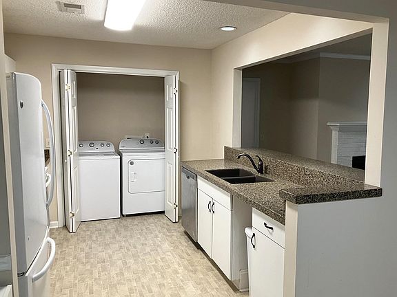 Open plan kitchen with washer/dryer, dishwasher, disposal.