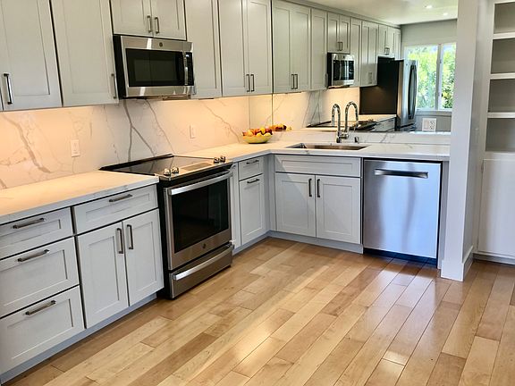 Recently remodeled, modern, sunny kitchen with new cabinets, appliances, stone countertops and recessed lighting.