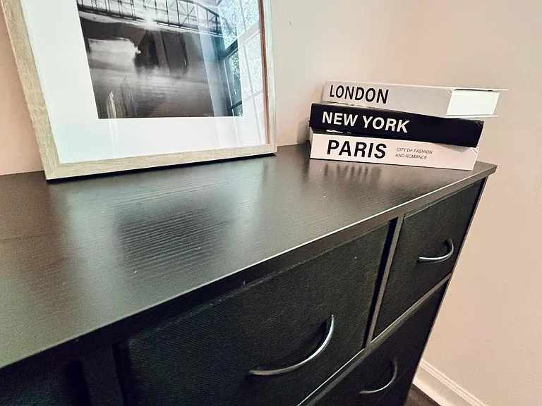 Storage area with a multi-drawer dresser and a display surface for personal items and decor.