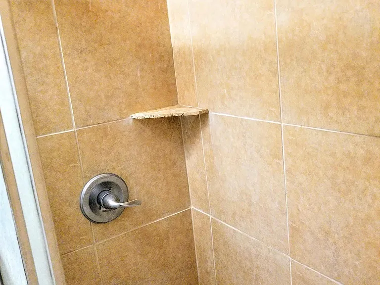Bathroom with toilet, sink, and full shower with tub