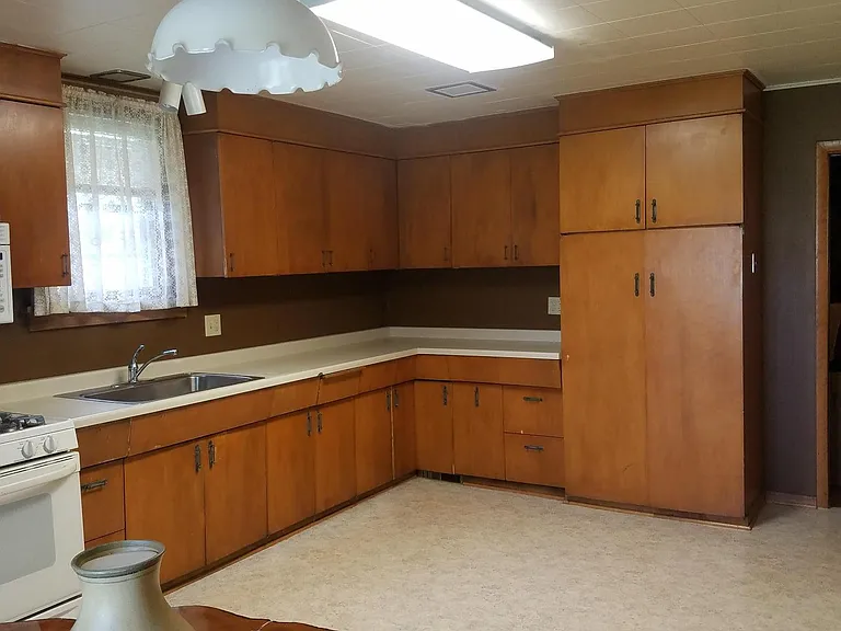 One end of the kitchen with lots of cabinets and countertops; note the farm sink!