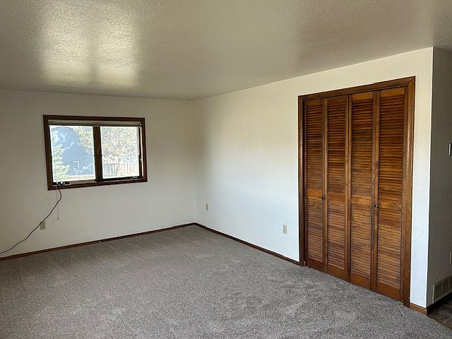 Another view of living room. Furnace and utility area behind louvered bi-folds.