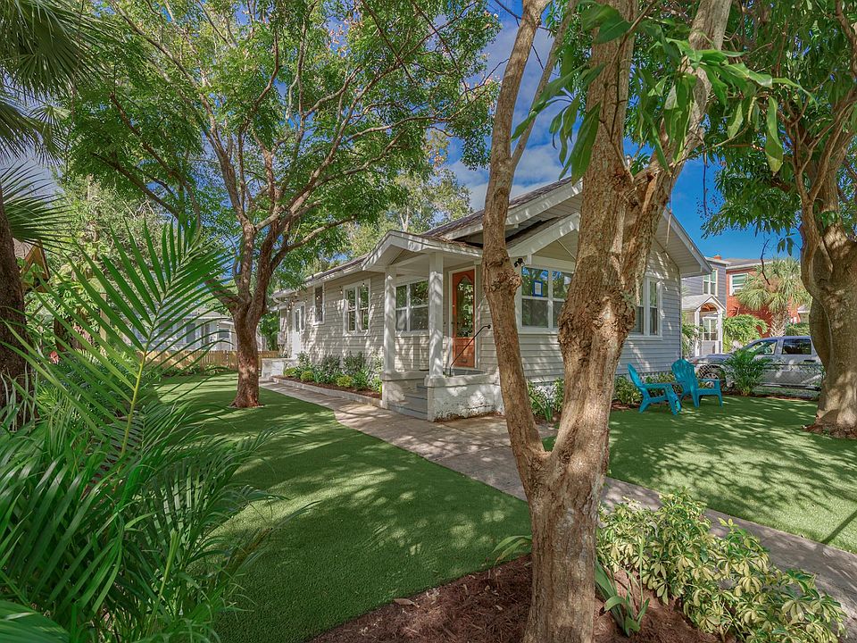Spacious and shaded yard features artificial turf