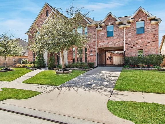 Estate style home with a gated porte-cochere, parking for one, a two-car attached garage and a one car detached garage to the left.