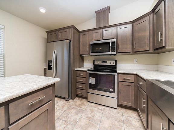 Kitchen - Solid wood cabinets, upgraded stainless appliance package, upgraded nickel hardware, large kitchen island, title back splashes, country farm sink, skylight, recessed lighting.