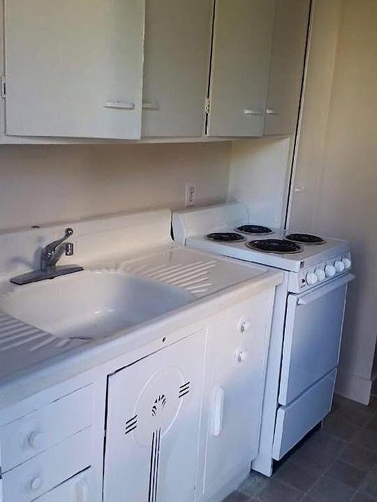 Enter into the kitchen. Original 1940 era metal sink cabinet; sink with built in dry rack. Beautifully vintage.