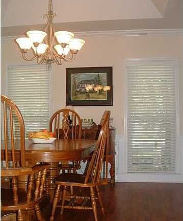 Dining room w/ tray ceiling and wainscoting.